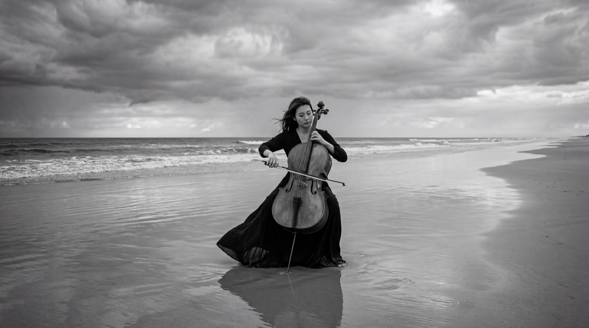 The cellist, mid-performance on the shoreline
